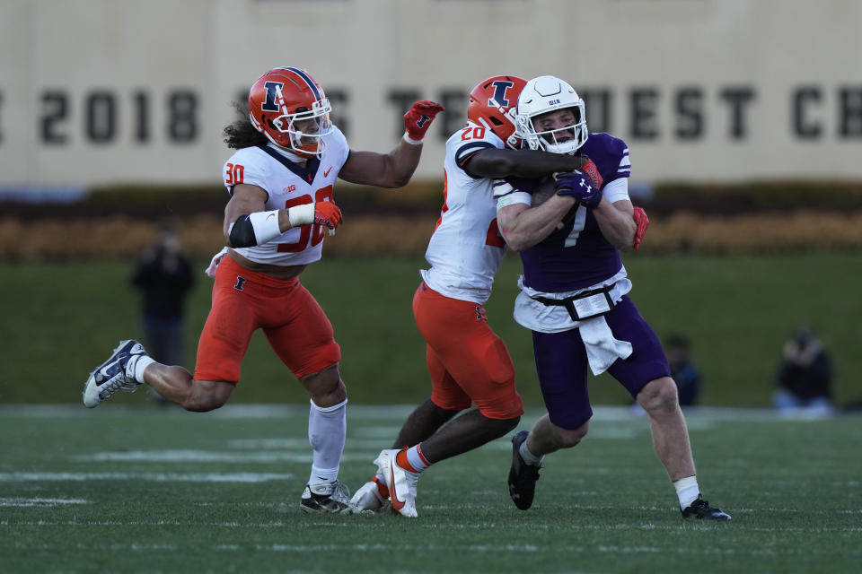 Northwestern quarterback Cole Freeman is tackled by Illinois defensive back Tyler Strain during the first half of an NCAA college football game in Evanston, Ill., Saturday, Nov. 26, 2022. (AP Photo/Nam Y. Huh)