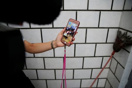 A woman displays footage on a mobile phone which she says shows residents detained by police in Wukan, Guangdong province, China, September 14, 2016. REUTERS/Damir Sagolj/File Photo