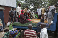 Relatives prepare to ride in the back of a truck with the coffins of villagers who were killed by suspected rebels as they retreated from Saturday's attack on the Lhubiriha Secondary School, outside the mortuary of the hospital in Bwera, Uganda Sunday, June 18, 2023. Ugandan authorities have recovered the bodies of 41 people including 38 students who were burned, shot or hacked to death after suspected rebels attacked the school in Mpondwe near the border with Congo, according to the local mayor. (AP Photo/Hajarah Nalwadda)