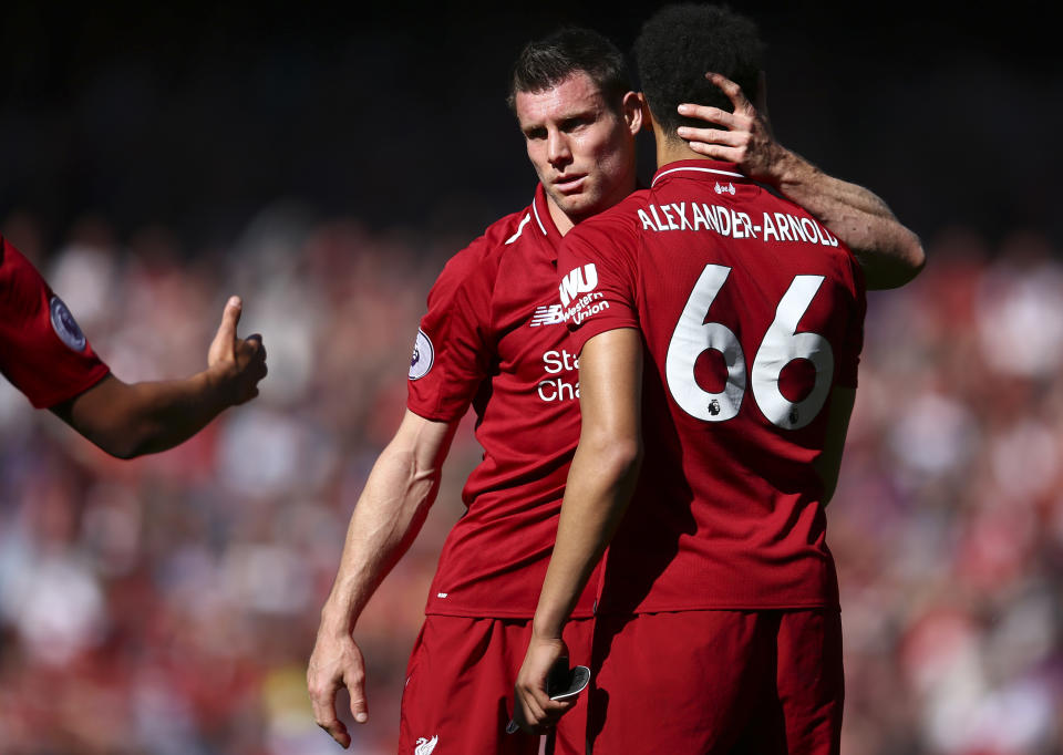 James Milner, centro, abraza a su cmpañero Trent Alexander-Arnold, ambos del Liverpool, al final de su partido por la Liga Premier ante Wolverhampton Wanderers, en el estadio Anfield de Liverpool, Inglaterra, el domingo 12 de mayo de 2019. (AP Foto/Dave Thompson)