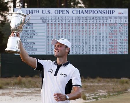 Martin Kaymer of Germany lifts his trophy after winning the U.S. Open Championship golf tournament in Pinehurst, North Carolina, June 15, 2014. REUTERS/Mike Segar