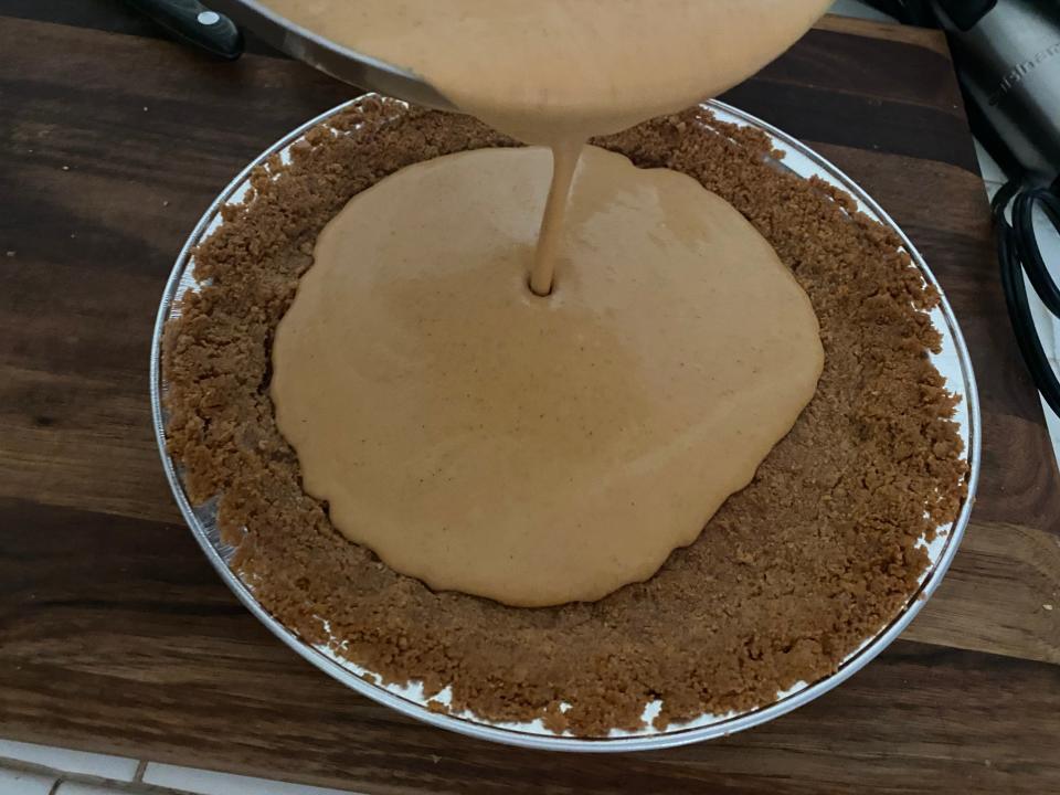 pouring the filling into Bobby Flay's pumpkin pie crust