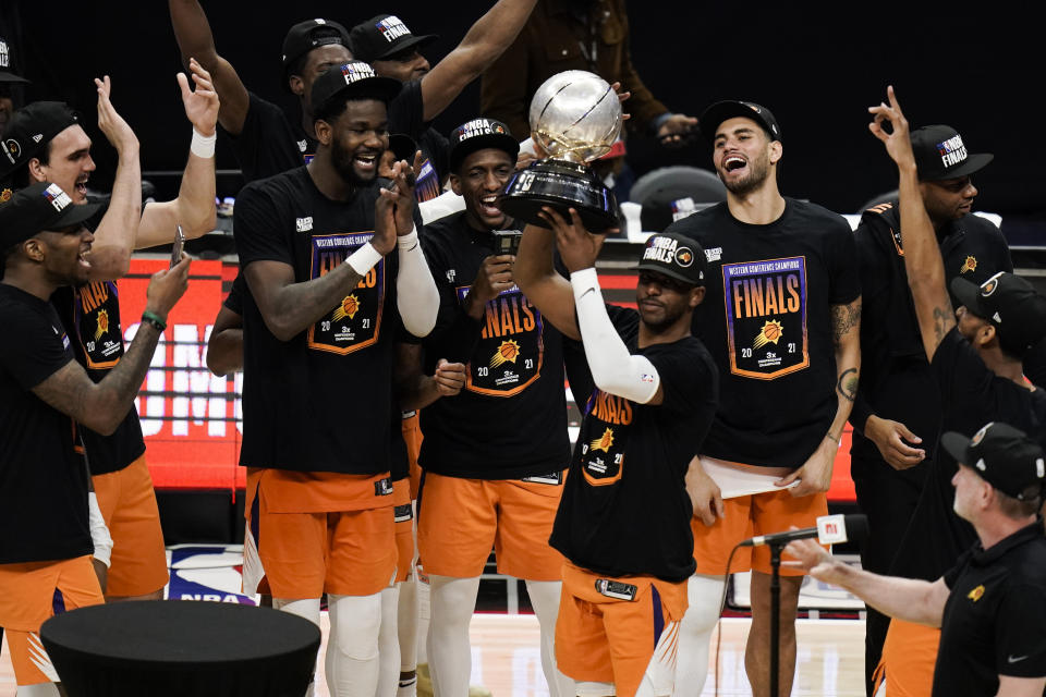 Phoenix Suns' Chris Paul hoists the trophy as he and his teammates celebrate after defeating the Los Angeles Clippers in Game 6 of the NBA basketball Western Conference Finals Wednesday, June 30, 2021, in Los Angeles. (AP Photo/Jae C. Hong)