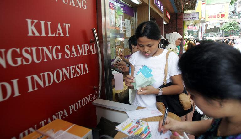 Indonesian domestic helpers fill in remittance forms at a remittance center in Hong Kong, on August 20, 2006