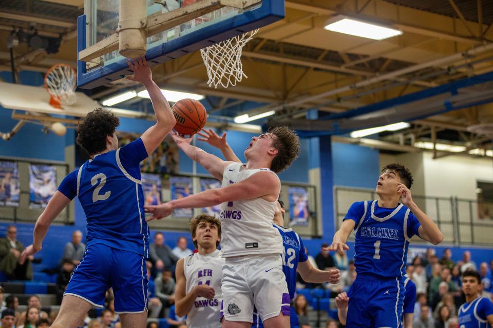 RFH's Nick Rigby shoots the ball around several Holmdel players during the first half of the Rumson-Fair Haven vs. Holmdel boys basketball game at Holmdel High School in Holmdel, NJ Wednesday, February 28, 2024.