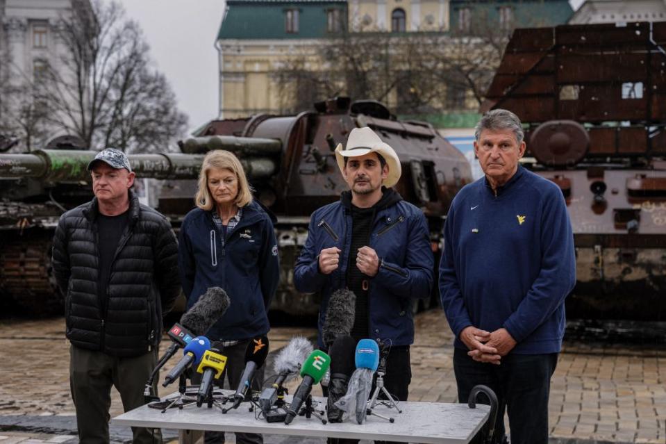 (L to R) U.S. senators Democrat Mark Kelly of Arizona, Republican Lisa Murkowski of Alaska, U.S. country star Brad Paisley and Democrat Joe Manchin of West Virginia attend a news conference in front of destroyed Russian military equipment at the Mikhailovsky Square in Kyiv on April 12, 2023, amid the Russian invasion of Ukraine. (Photo by Dimitar DILKOFF / AFP) (Photo by DIMITAR DILKOFF/AFP via Getty Images)