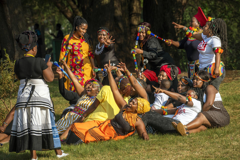 A group of women dressed in traditional clothing pose for a selfie as they celebrate South Africa's Heritage Day at Zoo Lake park in Johannesburg Thursday Sept. 24, 2020. As the number of worldwide Covid-19 death is nearing the million mark, coronavirus related case numbers and deaths in South Africa hit the lowest in months. (AP Photo/Jerome Delay)