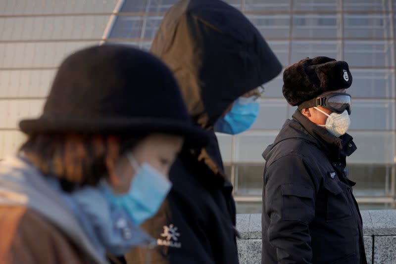 People wearing face masks walk near the National Centre for the Performing Arts, following an outbreak of the novel coronavirus in the country, in Beijing