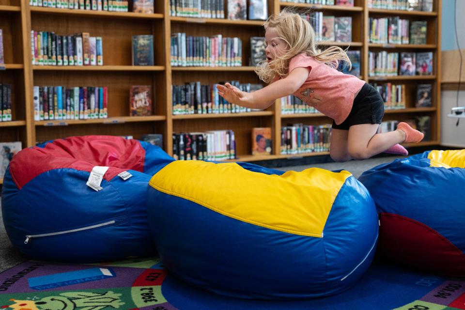 Cora Stout, of Alta, plays on the bean bag chairs in the Alta Community Library, on Tuesday, August 1, 2023, in Alta. The library is shared by the community and the school district.