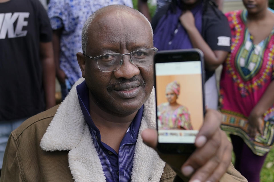 Sophonie Bizimana, a permanent U.S. resident who is a refugee from Congo, poses for a photo, Wednesday, Oct. 14, 2020, at his home in Kirkland, Wash., as he displays a cell-phone photo of his wife, Ziporah Nyirahimbya, who is in Uganda and has been unable so far to join him in the U.S. For decades, America admitted more refugees annually than all other countries combined, but that reputation has eroded during Donald Trump's presidency as he cut the number of refugees allowed in by more than 80 percent. (AP Photo/Ted S. Warren)