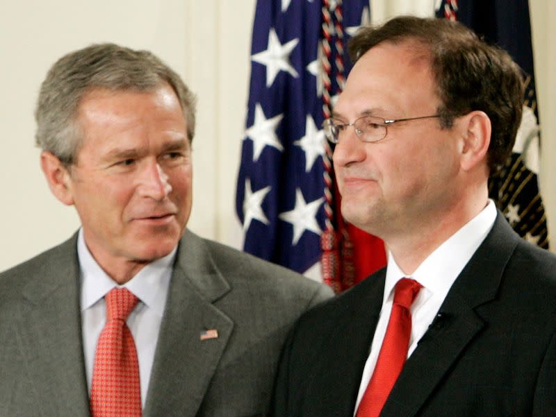 FILE PHOTO: U.S. President George W. Bush smiles alongside new Supreme Court Justice Alito in Washington