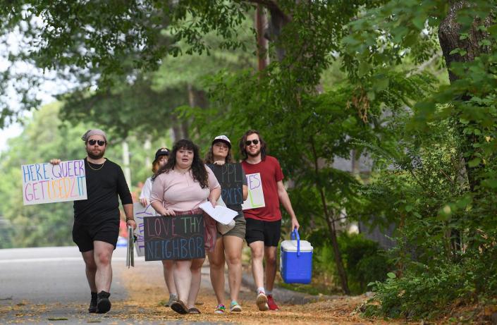 A group walks with signs toward the front arch of Anderson University in support of former professor Miranda Barnett in Anderson Sunday, June 26, 2022.