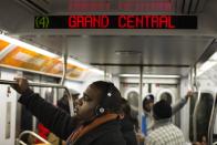 A commuter listens to music as he rides the 4 train towards Grand Central in New York, February 1, 2013. Grand Central Terminal, the doyenne of American train stations, is celebrating its 100th birthday. Opened on Feb. 2, 1913 the iconic New York landmark with its Beaux-Arts facade is an architectural gem, and still one of America's greatest transportation hubs. (REUTERS/Lucas Jackson)