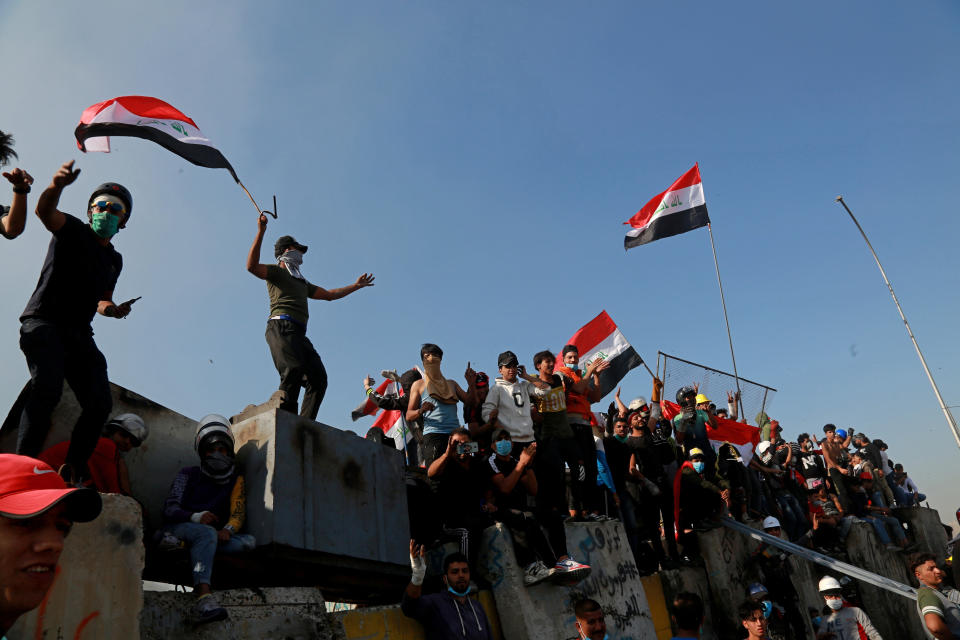 Protesters celebrate while taking control of some concrete walls and barriers set by security forces to close Sinak bridge leading to the Green Zone government areas during clashes between Iraqi security forces and anti-government demonstrators in Baghdad, Iraq, Saturday, Nov. 16, 2019. Iraqi security and medical officials say protesters have pushed closer to the Green Zone, Baghdad’s fortified seat of government, after security forces pulled back following a night of violent altercations.(AP Photo/Khalid Mohammed)