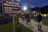 Voters wait in the dark before polls open on the first day of in-person early voting in Florida, at the Spanish River Library in Boca Raton, Monday, Oct. 19, 2020. (Joe Cavaretta/South Florida Sun-Sentinel via AP)