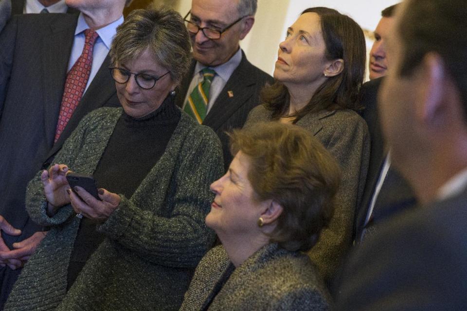 Senate Environment and Public Works Committee Chairman Sen. Barbara Boxer, D-Calif., left, checks her phone during a meeting of the Senate Climate Action Task Force prior to taking to the Senate Floor all night to urge action on climate change on Monday, March 10, 2014, in Washington. From left, Boxer, Sen. Chuck Schumer, D-N.Y., Sen. Jeanne Shaheen, D-N.H., and Sen. Maria Cantwell, D-Wash. (AP Photo/ Evan Vucci)