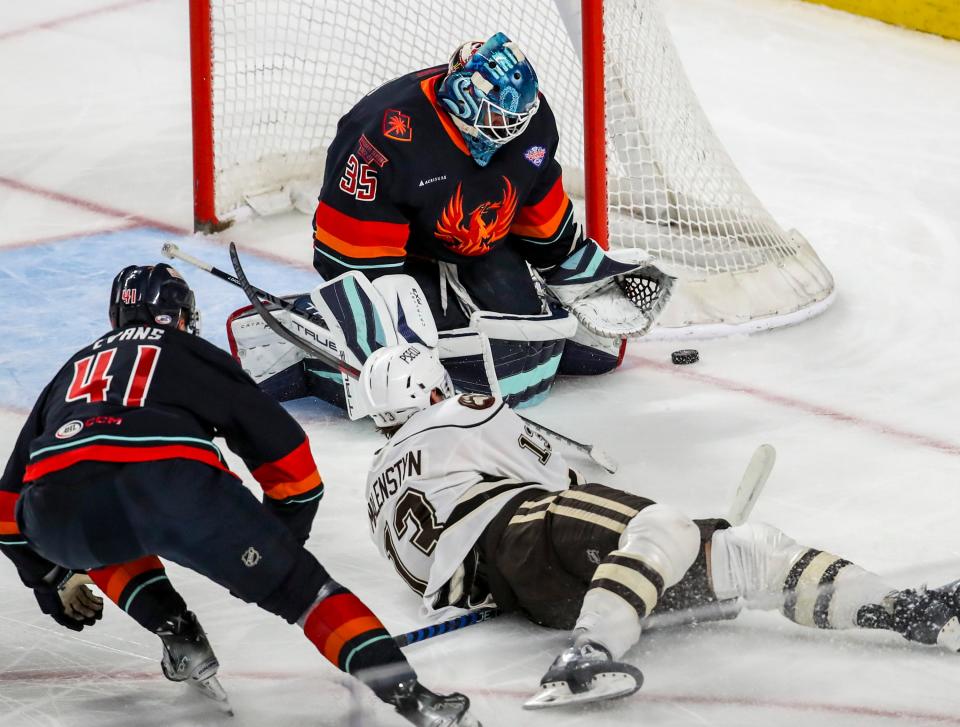 Coachella Valley goaltender Joey Daccord (35) makes a stop as Hershey forward Beck Malenstyn (13) slides down onto the ice during the first period of Game 2 of the Calder Cup Finals at Acrisure Arena in Palm Desert, Calif., Saturday, June 10, 2023.