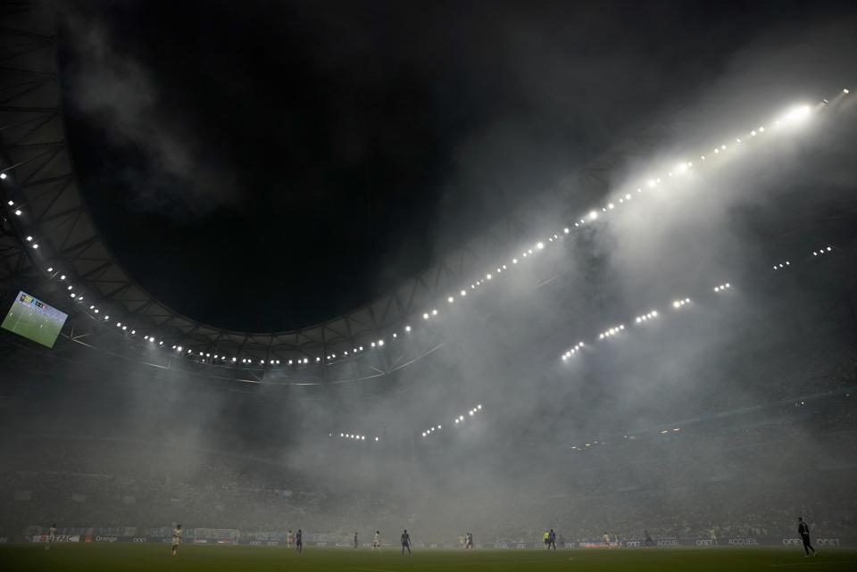 Smoke from flares lingers in the air during the French League One soccer match between Marseille and Lyon in Marseille, France, Sunday, May 1, 2022. (AP Photo/Daniel Cole)