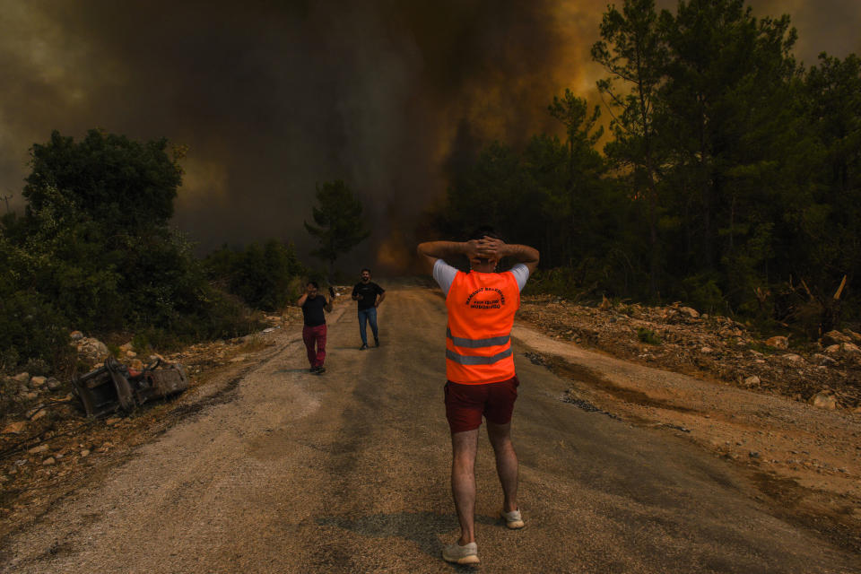 FILE - In this Sunday, Aug. 1, 2021 file photo, people run away from the fire-devastated Sirtkoy village, near Manavgat, Antalya, Turkey. Scientists say there’s something different this year from the recent drumbeat of climate weirdness. This summer a lot of the places hit by weather disasters are not used to getting extremes and many of them are wealthier, which is different from the normal climate change victims. That includes unprecedented deadly flooding in Germany and Belgium, 116-degree heat records in Portland, Oregon and similar blistering temperatures in Canada, along with wildfires. Now Southern Europe is seeing scorching temperatures and out-of-control blazes too. And the summer of extremes is only getting started. Peak Atlantic hurricane and wildfire seasons in the United States are knocking at the door. (AP Photo, File)