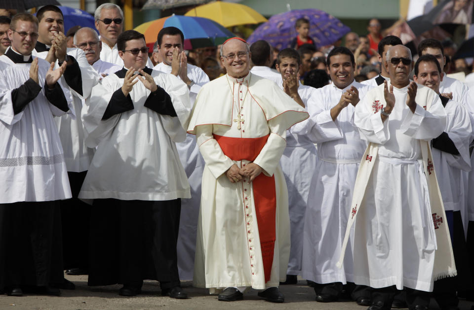 FILE - In this Sept. 4, 2011 file photo, Cuba's Cardinal Jaime Ortega, center, smiles as he waits for the arrival of "La Virgen de la Caridad del Cobre," procession in Madruga, Cuba. Cuba's Roman Catholic Church said Friday, July 26, 2019, the former archbishop of Havana who helped organize the first papal visit to communist Cuba has died. Ortega was 83. (AP Photo/Javier Galeano, File)