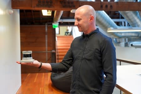 Ouster's Communications Manager Damon Lavrinc shows the lidar used in scanning the area on a self-driving vehicle, at the technology company's office in San Francisco