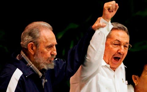2011: Fidel Castro, left, raises his brother's Raul's hand, as they sing the anthem of international socialism during the 6th Communist Party Congress in Havana - Credit: Javier Galeano/ AP