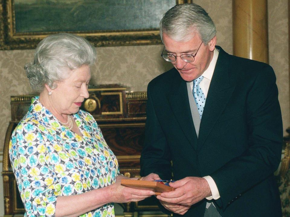 Queen Elizabeth presenting Sir John Major with a medal in 1999.