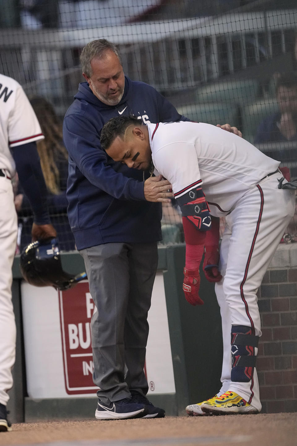 Atlanta Braves' Orlando Arcia is checked by a member of the training staff after he was hit by a pitch during the second inning of the team's baseball game against the Cincinnati Reds on Wednesday, April 12, 2023, in Atlanta. (AP Photo/John Bazemore)