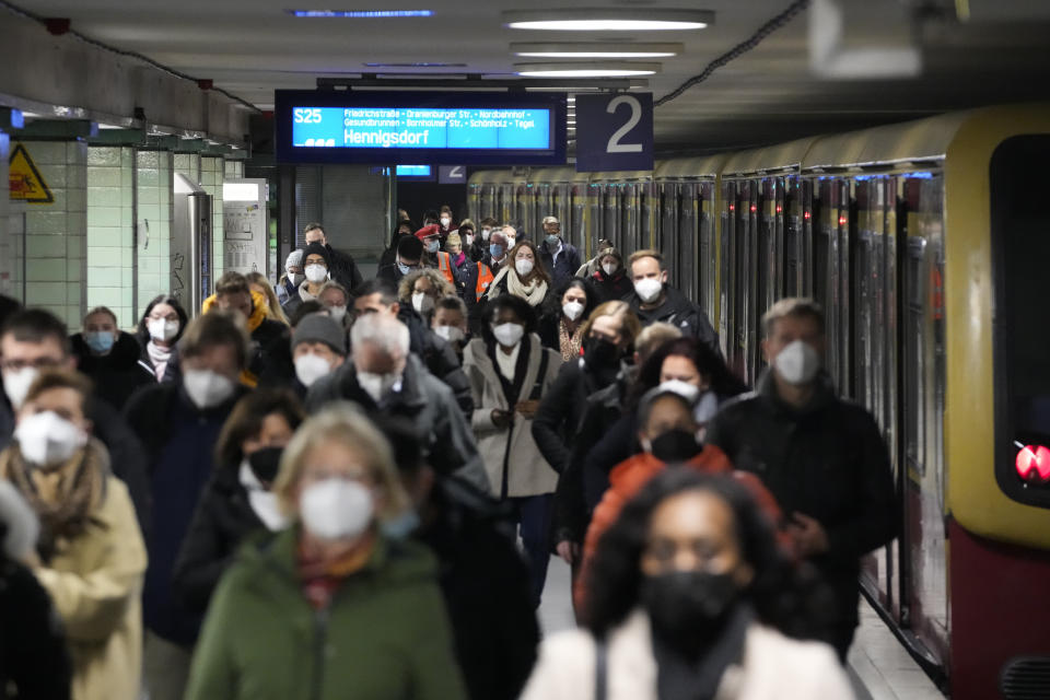 Commuters wearing face masks to protect against the coronavirus as they arrives at the public transport station Brandenburger Tor in central Berlin, Germany, Friday, Nov. 12, 2021. Germany battles a fourth wave of the coronavirus with high number of infections in the recent days. (AP Photo/Markus Schreiber)