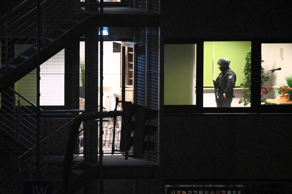 Police officers in special equipment walk through a Jehovah's Witness building in Hamburg, Germany, Thursday, March 9, 2023. German police say shots were fired inside a building used by Jehovah’s Witnesses in Hamburg.