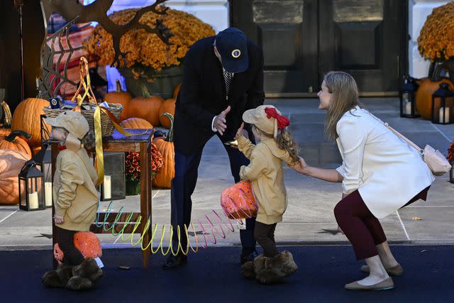 <p>Celal Gunes/Anadolu via Getty </p> Joe Biden with a trick or treater