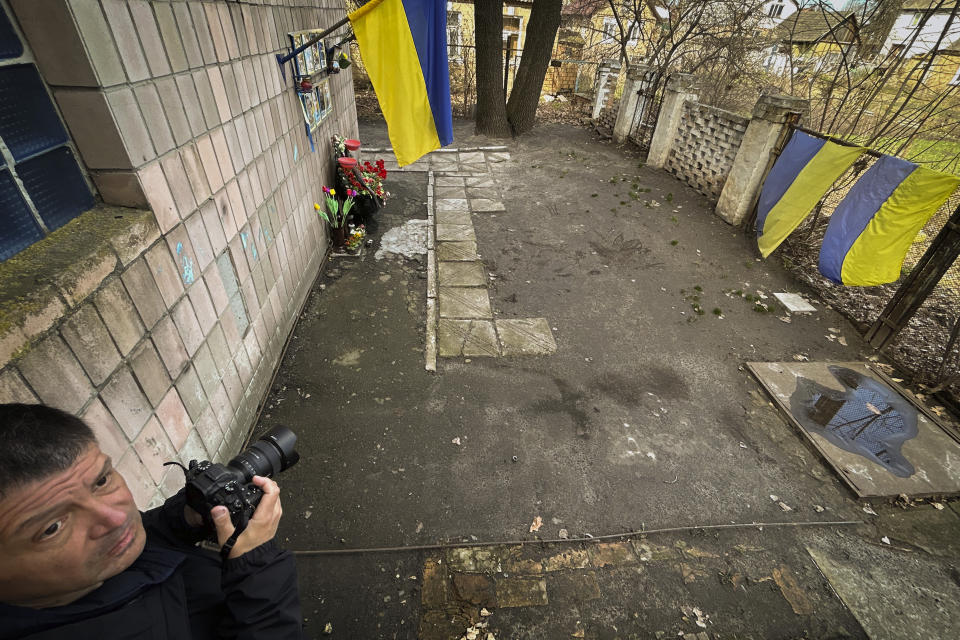 Photographer Vadim Ghirda tries to reproduce the angle of the photo he took of the bodies of eight men killed by Russian forces in 2022 in Bucha, Ukraine, Saturday March 30, 2024. The photo showed bodies of men, some with their hands tied behind their backs, lying on the ground. It was part of a series of images by Associated Press photographers that was awarded the 2023 Pulitzer Prize for Breaking News Photography. (AP Photo/Enric Marti)