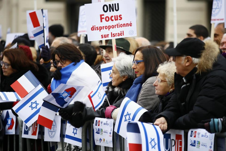 Pro-Israel demonstrators hold a placard reading "United Nations Organization Disproportionate Focus on Israel" during a gathering in front of Israel embassy in Paris, France, Sunday, Jan. 15, 2017. Fearing a new eruption of violence in the Middle East, more than 70 world diplomats gathered in Paris on Sunday to push for renewed peace talks that would lead to a Palestinian state. (AP Photo/Francois Mori)