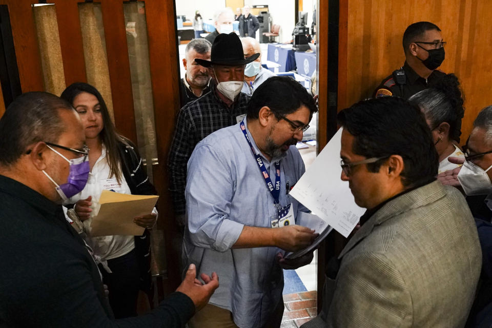 Cameron County Elections Administrator Remi Garza passes out the unofficial early voting counts Tuesday, March 1, 2022, on election day for the 2022 Democratic Election at the Cameron County Courthouse in Brownsville, Texas. (Denise Cathey/The Brownsville Herald via AP)