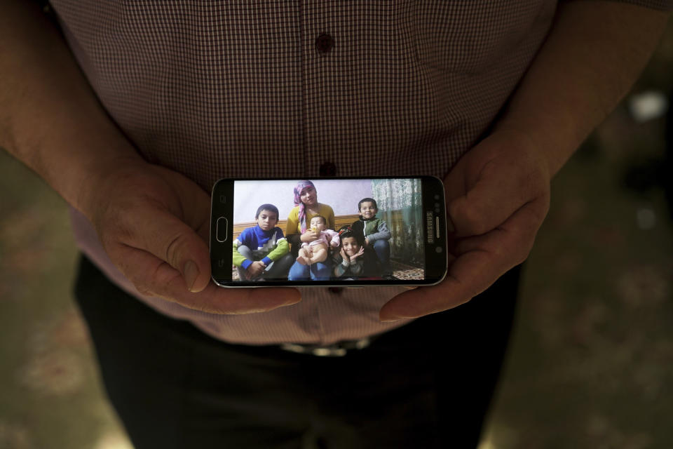 In this Aug. 23, 2018, photo, Adil, 42, father to five children and a businessman from Kashgar, China, holds a phone showing an image of his family left behind in China while being interviewed by the Associated Press in Istanbul, Turkey. He got stuck in Turkey during a business trip after hearing that the Chinese government was seizing passports, and hasn't seen his children since. Three of his children were ordered to attend newly-built boarding schools in Kashgar and Turpan before he got stuck in Turkey. (AP Photo/Dake Kang)