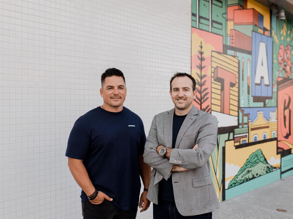 LawVu's cofounders, Tim Boyne and Sam Kidd, in front of an artsy wall