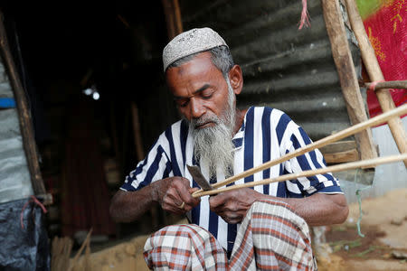 Hamid Hussain, a 71-year-old Rohingya refugee cuts firewood after an interview with Reuters at Kutupalong camp, near Cox's Bazar, Bangladesh January 13, 2018. Picture taken January 13, 2018.REUTERS/Tyrone Siu