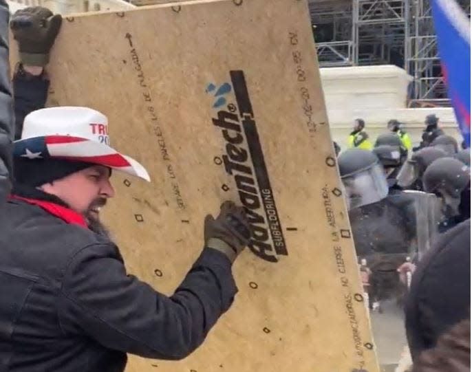 Footage from the Jan. 6 attack at the U.S. Capitol appeared to show Tennessee man Joshua John Portlock ramming into and climbing over officers with what looks like a piece of plywood, a court document showed.