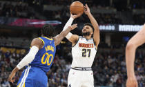 Denver Nuggets guard Jamal Murray (27) looks to shoot over Golden State Warriors forward Jonathan Kuminga (00) in the first half of an NBA basketball game Thursday, Feb. 2, 2023, in Denver. (AP Photo/David Zalubowski)