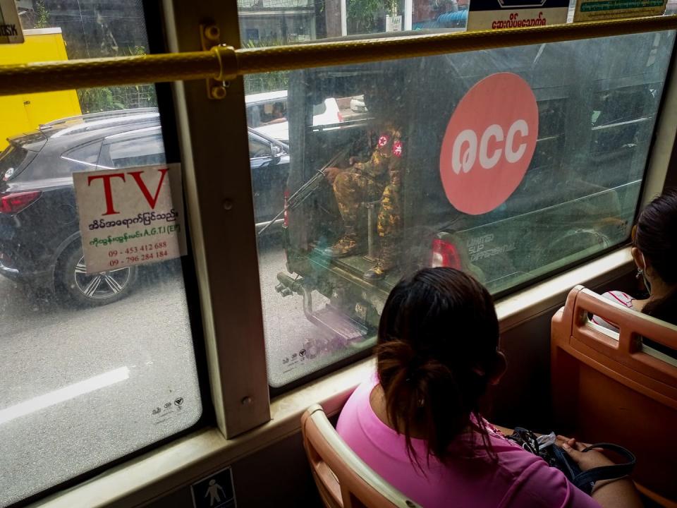 Women look out the window of a bus at armed soldiers patrolling a street in Yangon, Myanmar. <a href="https://media.gettyimages.com/photos/two-women-look-out-the-window-of-a-bus-as-armed-soldiers-patrol-a-picture-id1242116402?s=2048x2048" rel="nofollow noopener" target="_blank" data-ylk="slk:STR/NurPhoto via Getty Images;elm:context_link;itc:0;sec:content-canvas" class="link ">STR/NurPhoto via Getty Images</a>