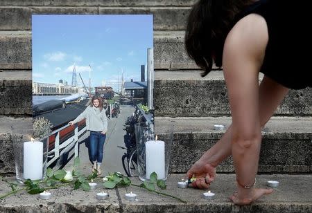 A woman lights a candle during a vigil in memory of murdered British lawmaker, Jo Cox, on what would have been her 42nd birthday in central Brussels, Belgium, June 22, 2016. REUTERS/Francois Lenoir