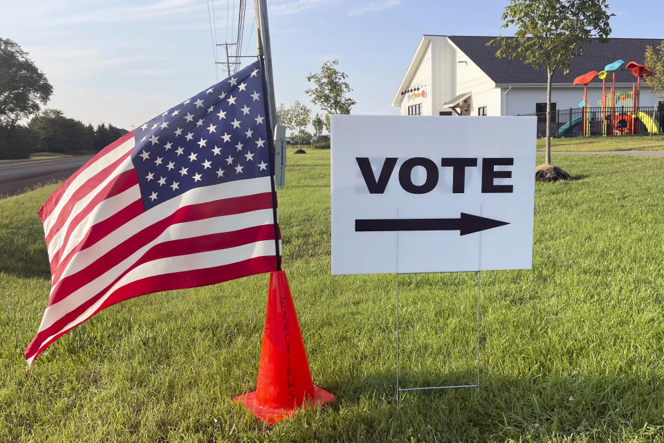 An American flag waves in the breeze next to a sign directing Ohioans to vote inside Tharp Sixth Grade School, Tuesday, Aug. 8, 2023 in Hilliard, Ohio. It’s the final day that Ohio citizens can vote in a GOP-rushed special election on whether to make the state constitution harder to amend, likely having direct impact on abortion rights in the state. (AP Photo/Samantha Hendrickson)