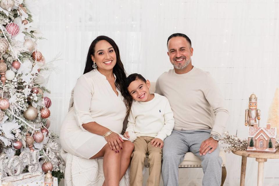 Ana Isabel Feliciano y su esposo, Armando Álvarez, posan para una foto navideña con su hijo.