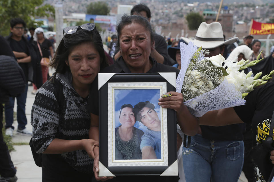 Familiares del fallecido Jhon Jennry Mendoza se dirigen al cementerio con su imagen un año después de su muerte durante las protestas contra el gobierno en Ayacucho, Perú, el viernes 15 de diciembre de 2023. La Comisión Interamericana de Derechos Humanos y el Alto Comisionado de Derechos Humanos de la ONU han requerido al gobierno peruano que investigue las denuncias de uso excesivo de la fuerza pública en las protestas de hace un año que dejaron 49 civiles muertos. (AP Foto/Silvio La Rosa)