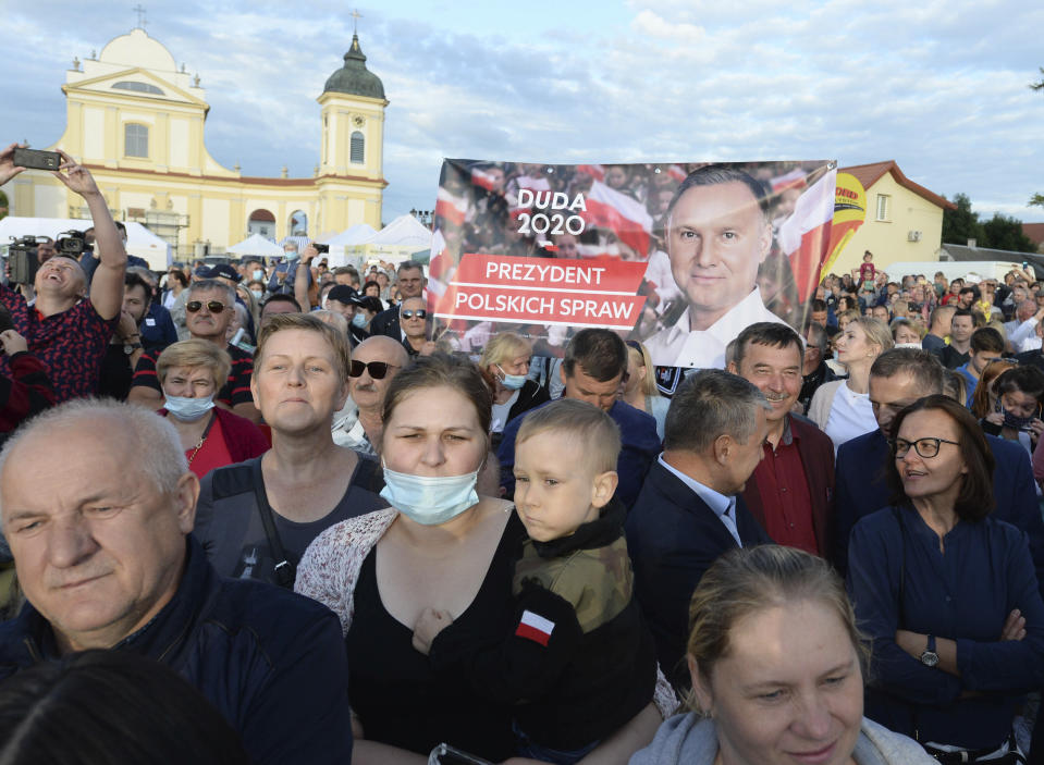 Supporters of Polish President Andrzej Duda hold up banners at a presidential election campaign rally in Tykocin, Poland, Tuesday, July 7, 2020. Two bitter rivals are heading into a razor's-edge presidential runoff election Sunday in Poland that is seen as an important test of populism in Europe after a campaign that exacerbated a conservative-liberal divide in the country. (AP Photo/Czarek Sokolowski)