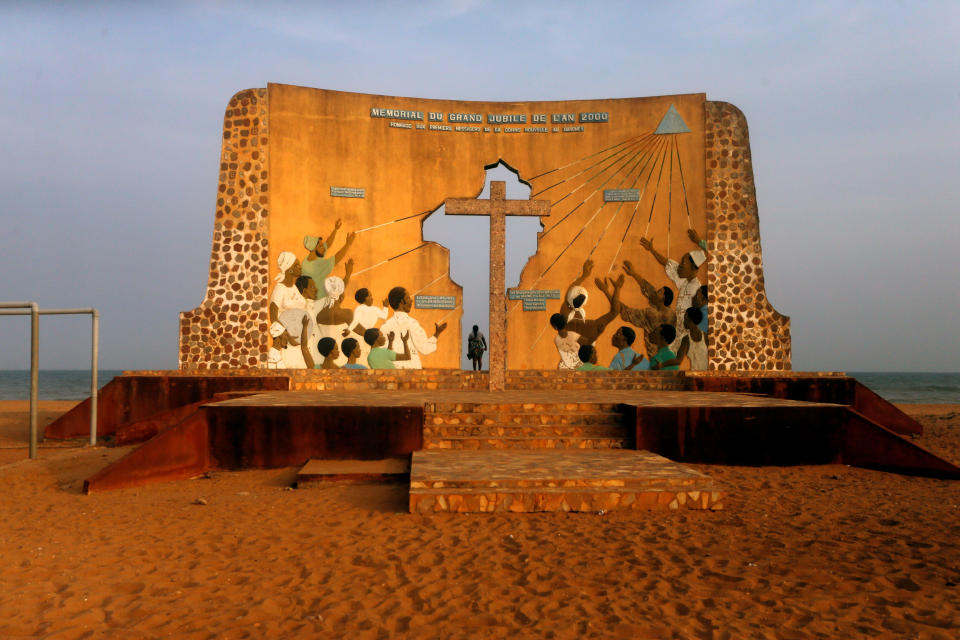 A woman stands beneath a monument commemorating the "Door of No Return" where slaves were loaded onto ships in the historic slave port town Ouidah, Benin. (Photo: Afolabi Sotunde/Reuters)