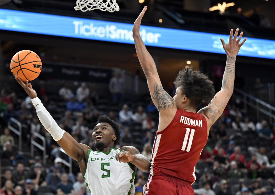 Oregon guard Jermaine Couisnard (5) shoots against Washington State forward DJ Rodman (11) during the second half of an NCAA college basketball game in the quarterfinals of the Pac-12 men's tournament Thursday, March 9, 2023, in Las Vegas. (AP Photo/David Becker)