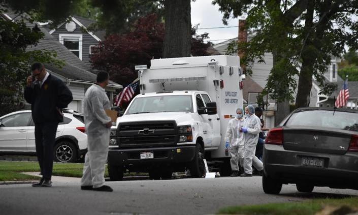 police and forensic teams on suburban road