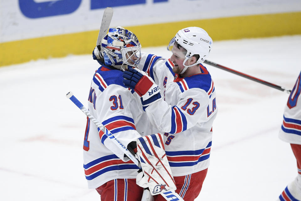 New York Rangers goaltender Igor Shesterkin (31) and left wing Alexis Lafrenière (13) celebrate after an NHL hockey game against the Washington Capitals, Saturday, Feb. 20, 2021, in Washington. The Rangers won 4-1. (AP Photo/Nick Wass)