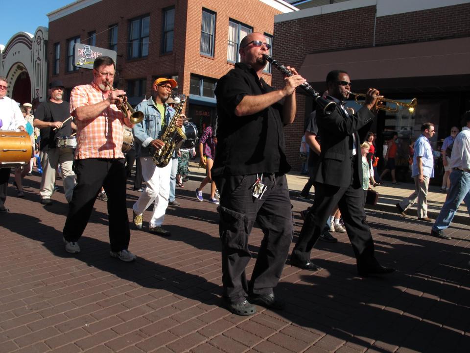 Horn players and drummers participate in a funeral parade down Memphis' Beale Street honoring late soul bassist Donald "Duck" Dunn on Wednesday, May 23, 2012 in Memphis, Tenn. More than 100 fans walked and danced down the Memphis drag during the New Orleans-style parade to remember Dunn, who died May 13 at age 70 while on tour in Japan. . (AP Photo/Adrian Sainz)